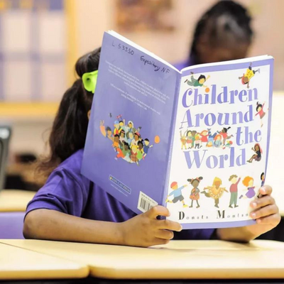 Child reading a book called 'Children Around the World'
